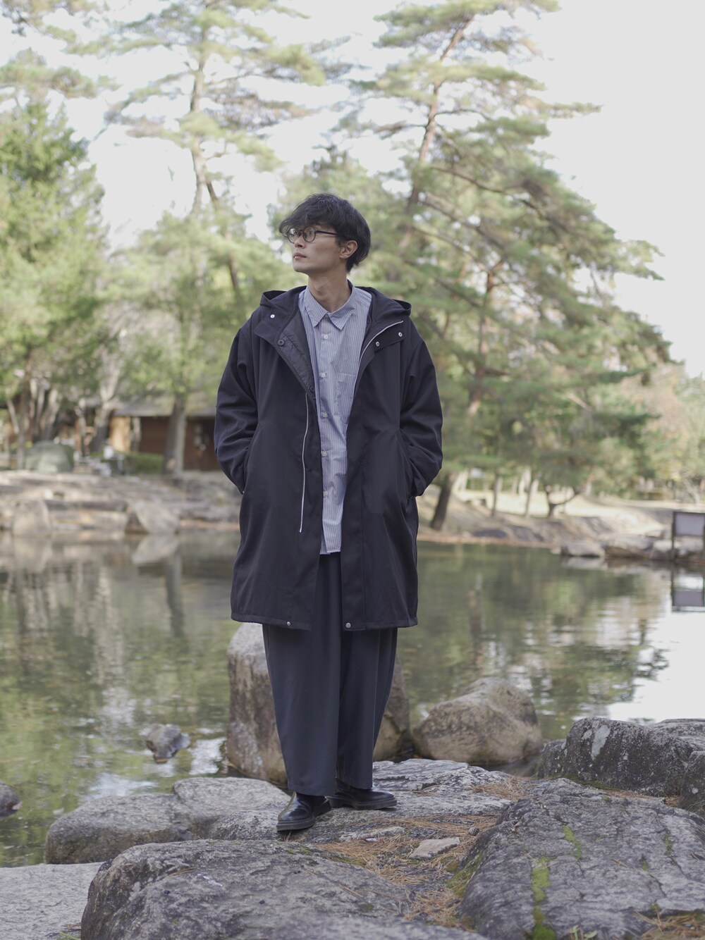 ブラック系のモッズコート、ブルー系のシャツ/ブラウス、ブルー系のスラックスを着用したメンズの冬コーディネートの1枚目の写真