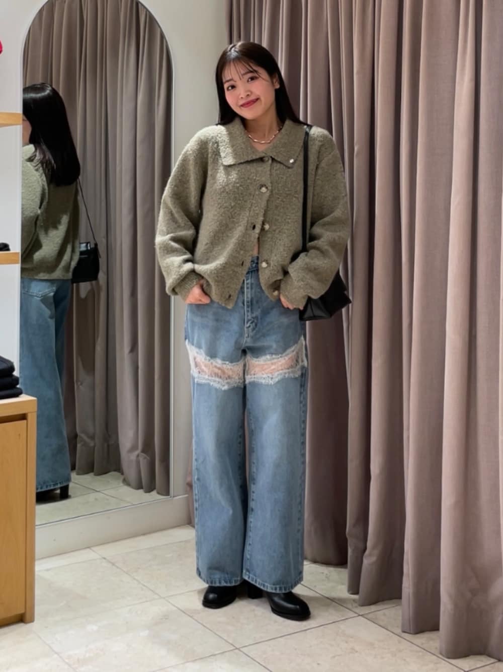 ブルー系のデニムパンツ、ブラック系のブーツ、ベージュ系のカーディガン/ボレロを着用したレディースの秋コーディネートの1枚目の写真