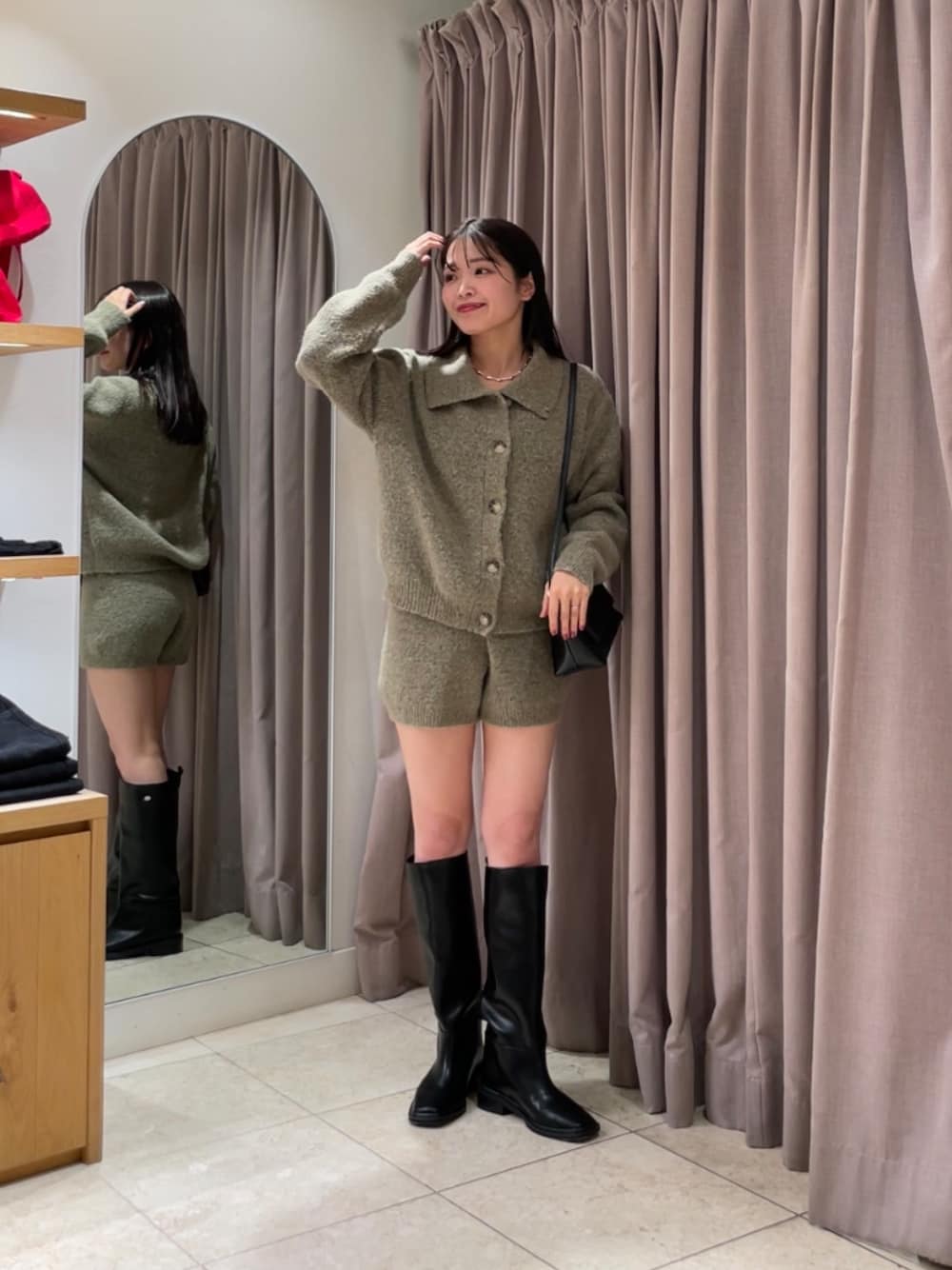 ベージュ系のカーディガン/ボレロ、ベージュ系のその他パンツ、ブラック系のブーツを着用したレディースの秋コーディネートの1枚目の写真