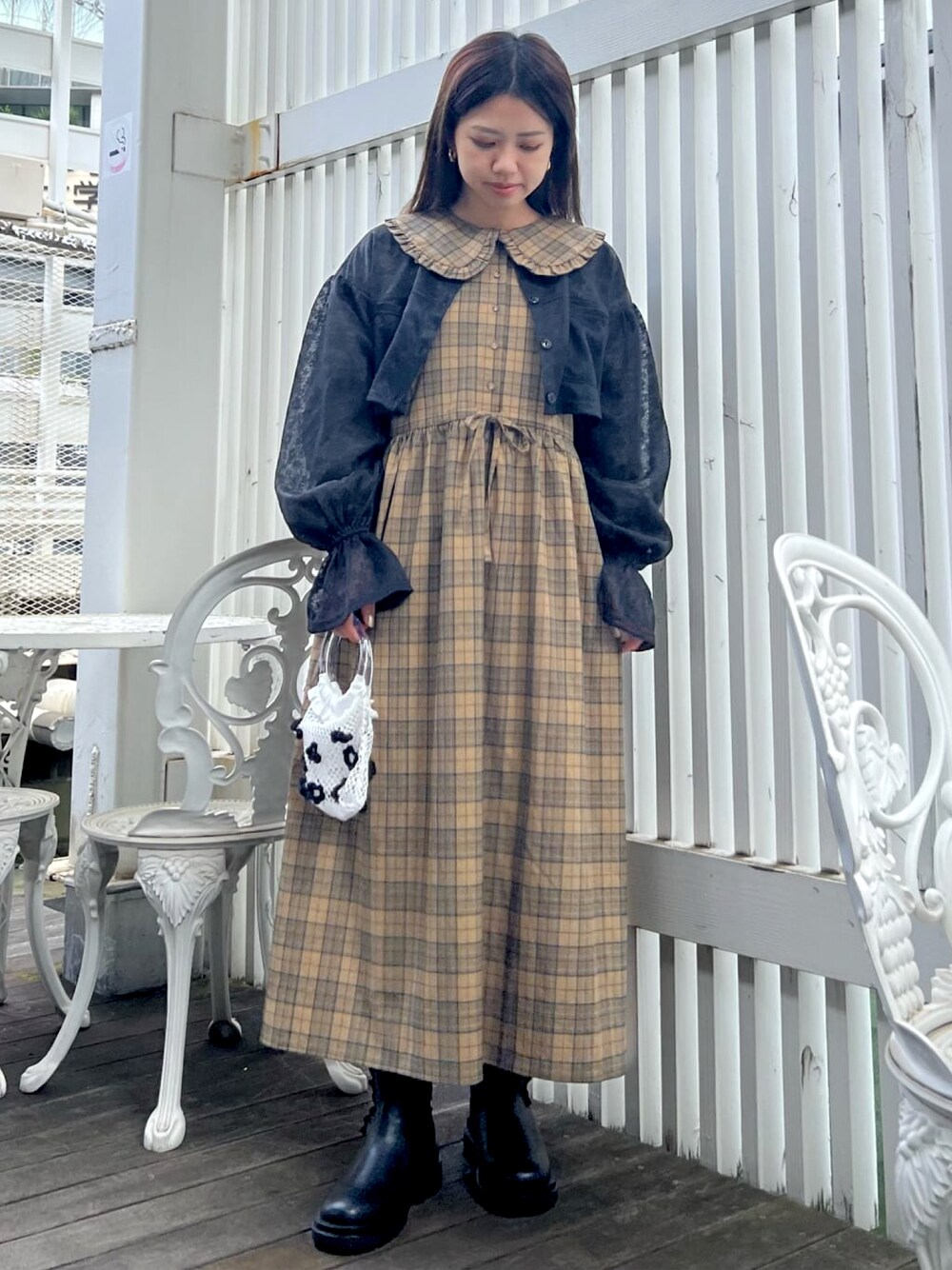 イエロー系のワンピース、ブラック系のシャツ/ブラウス、ホワイト系のハンドバッグを着用したレディースの夏コーディネートの1枚目の写真