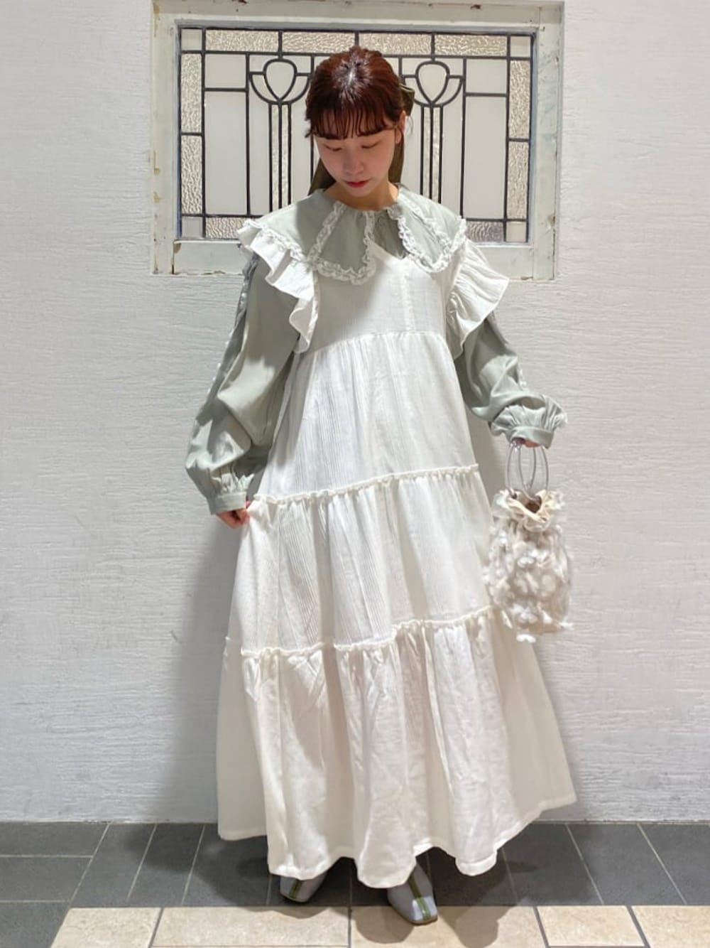 ホワイト系のワンピース、グリーン系のシャツ/ブラウス、ブルー系のパンプスを着用したレディースの冬コーディネートの1枚目の写真