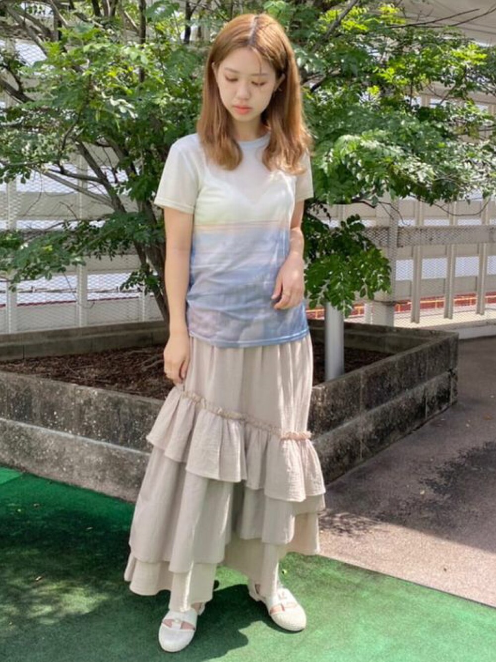 ブルー系のTシャツ/カットソー、ブラウン系のスカート、ホワイト系のパンプスを着用したレディースの夏コーディネートの1枚目の写真