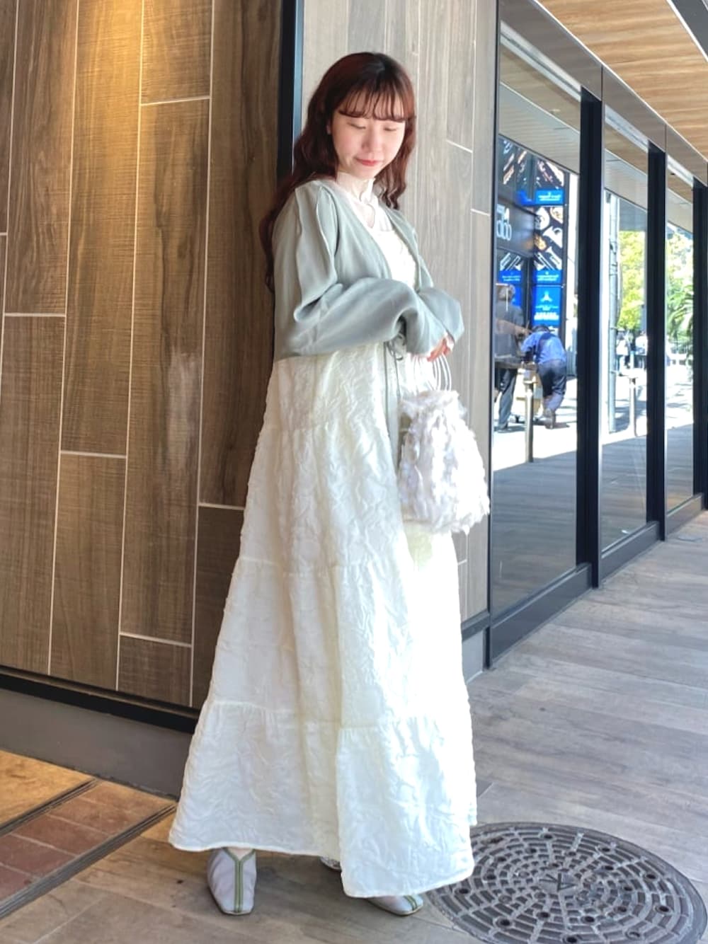 ホワイト系のワンピース、グリーン系のカーディガン/ボレロ、ホワイト系のTシャツ/カットソーを着用したレディースの春コーディネートの1枚目の写真