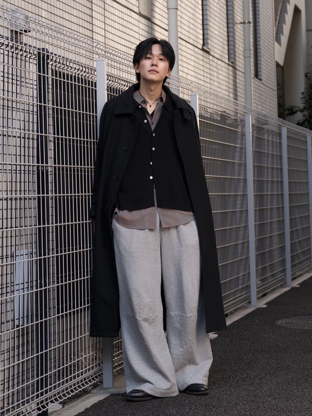 オレンジ系のシャツ/ブラウス、ブラック系のステンカラーコート、ブラック系のローファーを着用したメンズの冬コーディネートの1枚目の写真