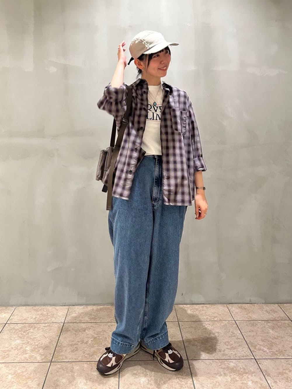 グレー系のショルダーバッグ、ブラウン系のシャツ/ブラウス、ホワイト系のTシャツ/カットソーを着用したレディースの秋コーディネートの1枚目の写真