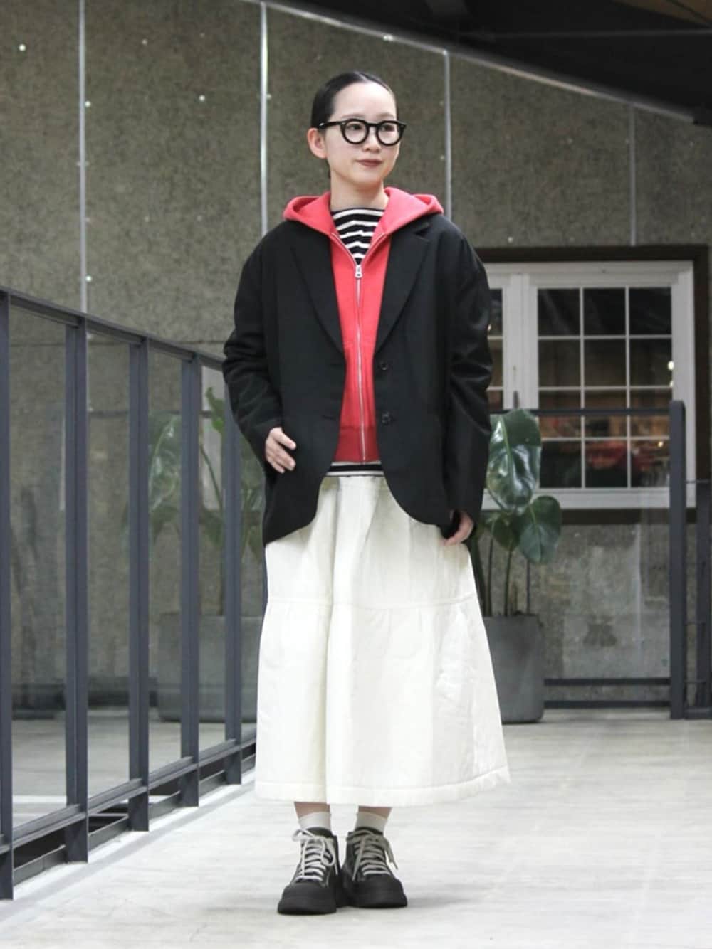 ブラック系のテーラードジャケット、レッド系のパーカー、ブラック系のTシャツ/カットソーを着用したレディースの春コーディネートの1枚目の写真