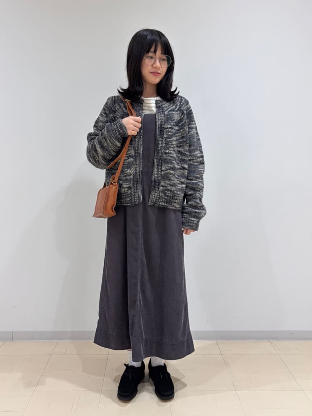 ブラック系のその他シューズ、ホワイト系のTシャツ/カットソー、ブラック系のカーディガン/ボレロを着用したレディースの冬コーディネートの1枚目の写真