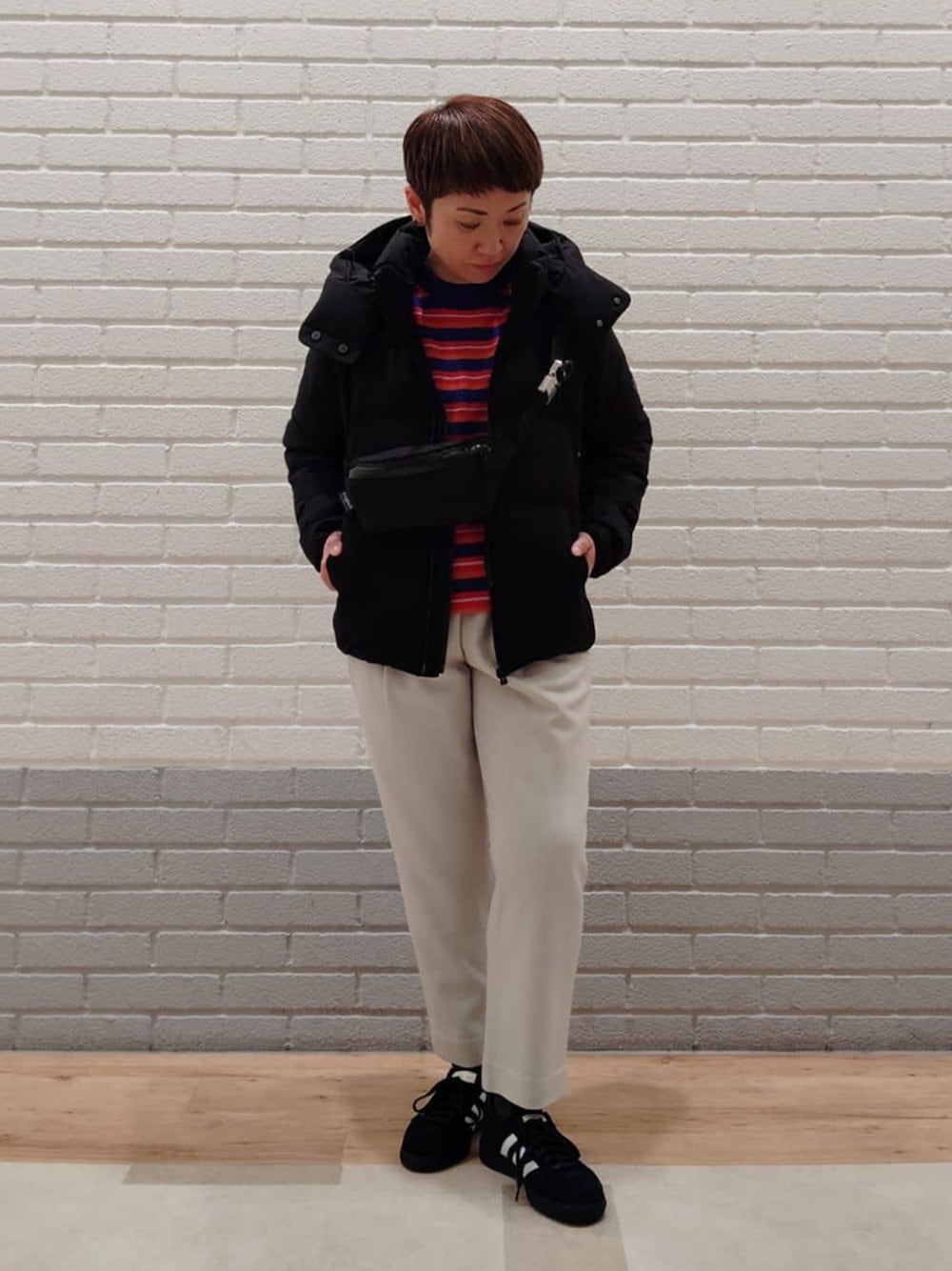 ブラック系のボディバッグ/ウエストポーチ、ブラック系のスニーカー、グレー系のその他パンツを着用したレディースの春コーディネートの1枚目の写真