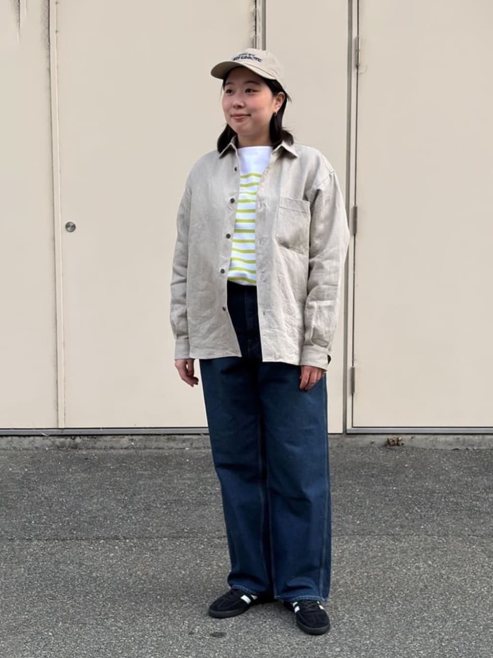 ブラック系のスニーカー、ブルー系のデニムパンツ、イエロー系のTシャツ/カットソーを着用したレディースの春コーディネートの1枚目の写真