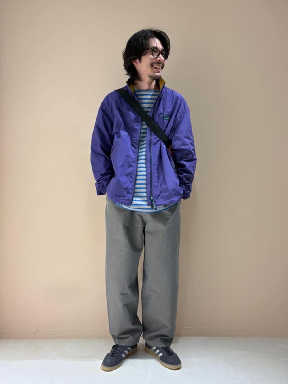 ブラック系のスニーカー、ブルー系のTシャツ/カットソー、オレンジ系のボディバッグ/ウエストポーチを着用したメンズの春コーディネートの1枚目の写真