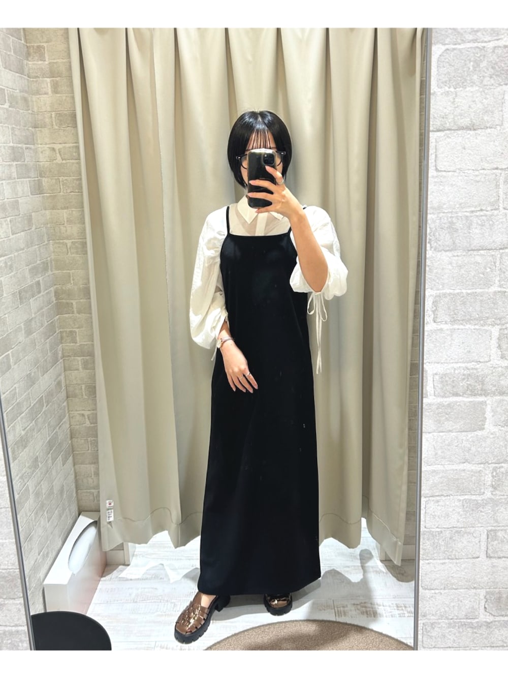 ブラック系のワンピース/ドレス、その他のサンダル、ホワイト系のアナログ腕時計を着用したレディースの秋コーディネートの1枚目の写真