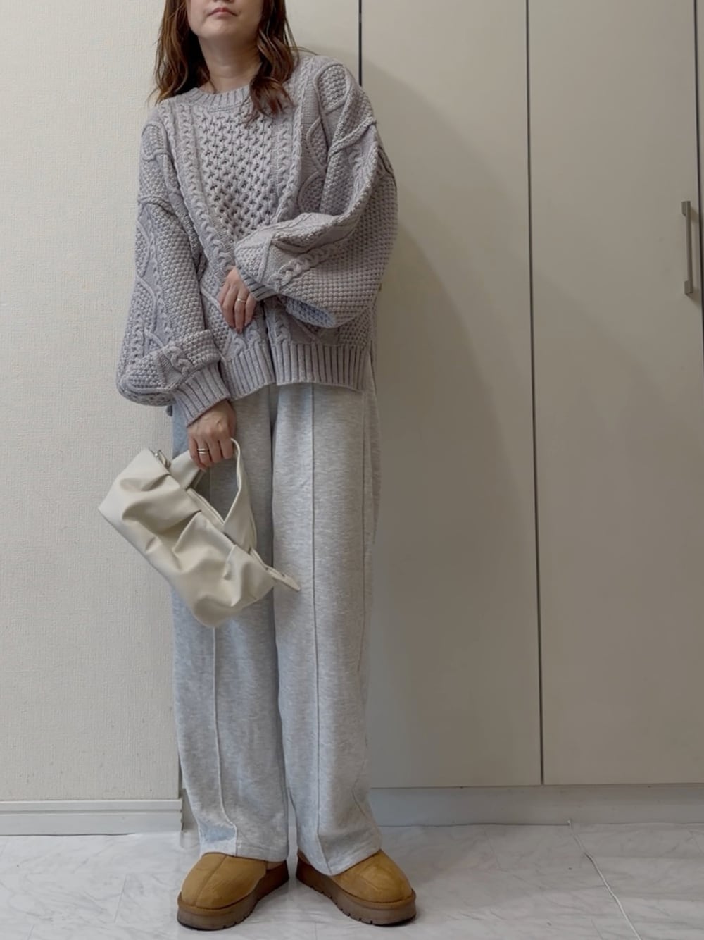 グレー系のニット/セーター、イエロー系のスニーカーを着用したレディースの冬コーディネートの1枚目の写真