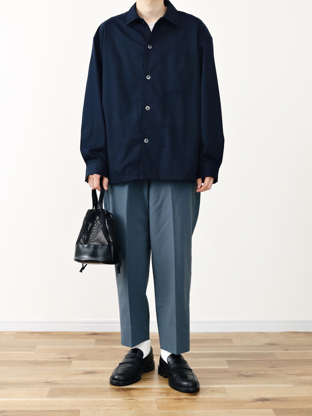 ブルー系のトップス、ブルー系のパンツ、ブラック系のトートバッグを着用したメンズの春コーディネートの1枚目の写真
