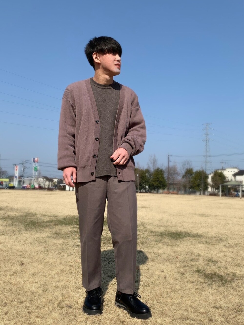 ブラウン系のカーディガン/ボレロ、ブラウン系のニット/セーター、ベージュ系のその他パンツを着用したメンズの春コーディネートの1枚目の写真