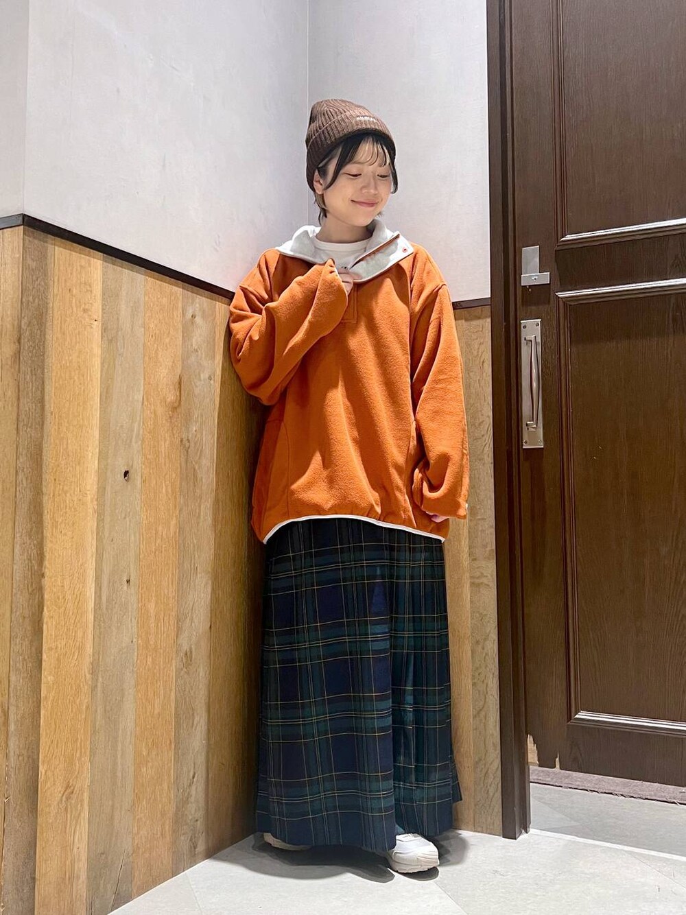 オレンジ系のスウェット、ホワイト系のTシャツ/カットソー、グリーン系のスカートを着用したレディースの秋コーディネートの1枚目の写真
