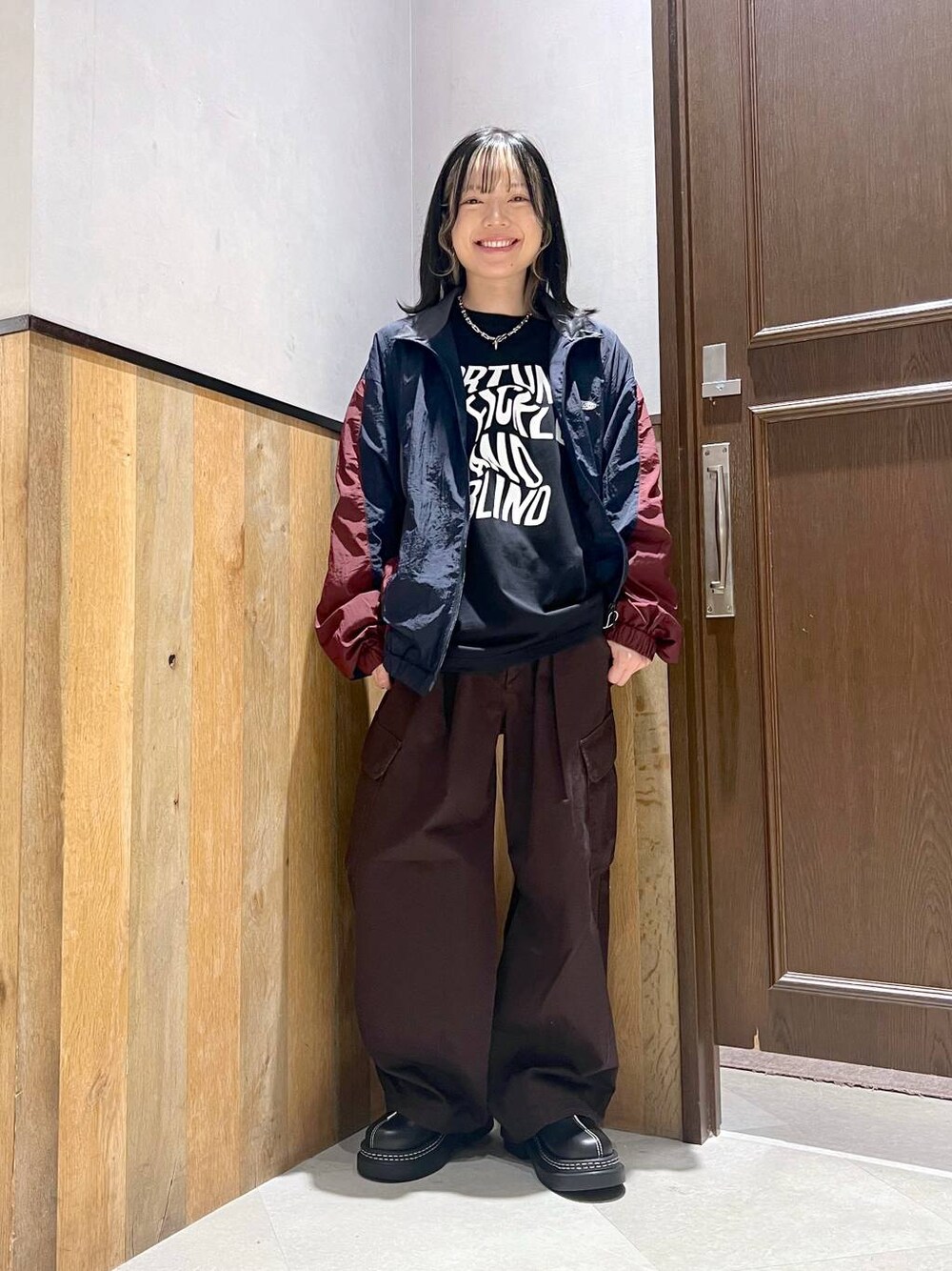 ブラウン系のカーゴパンツ、ブルー系のブルゾン、ブラック系のTシャツ/カットソーを着用したレディースの秋コーディネートの1枚目の写真