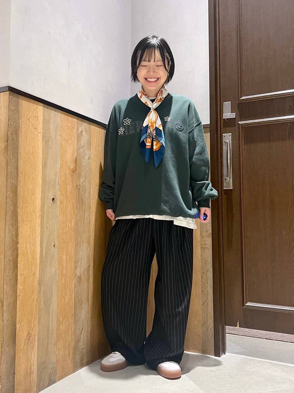 ブラック系のスラックス、ホワイト系のTシャツ/カットソー、グリーン系のスウェットを着用したレディースの秋コーディネートの1枚目の写真