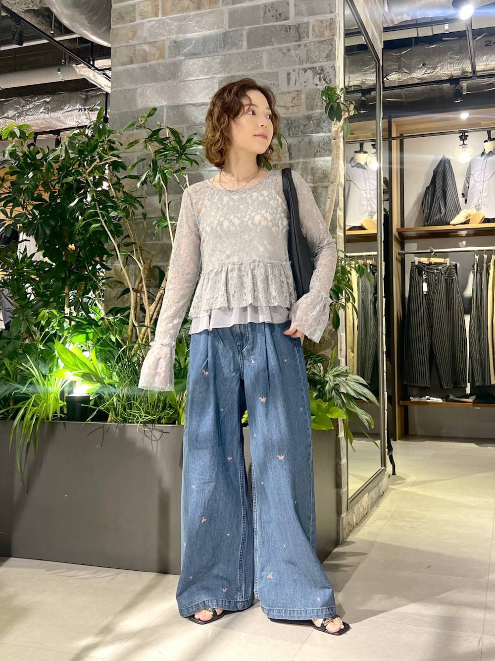 グレー系のTシャツ/カットソー、ブルー系のデニムパンツ、ブラック系のトートバッグを着用したレディースの夏コーディネートの1枚目の写真