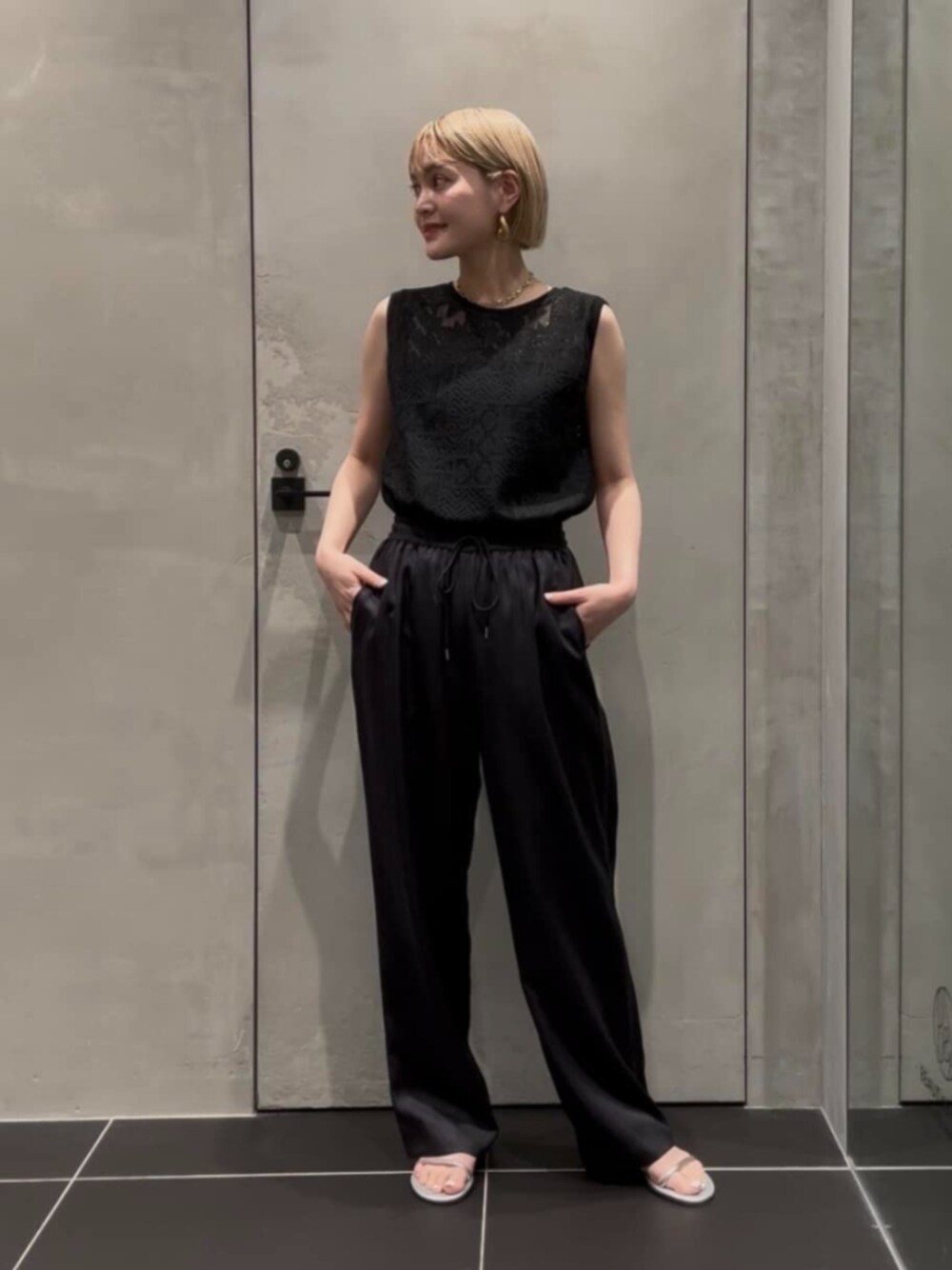 グレー系のその他パンツ、ブラック系のTシャツ/カットソー、シルバー系のサンダルを着用したレディースの夏コーディネートの1枚目の写真