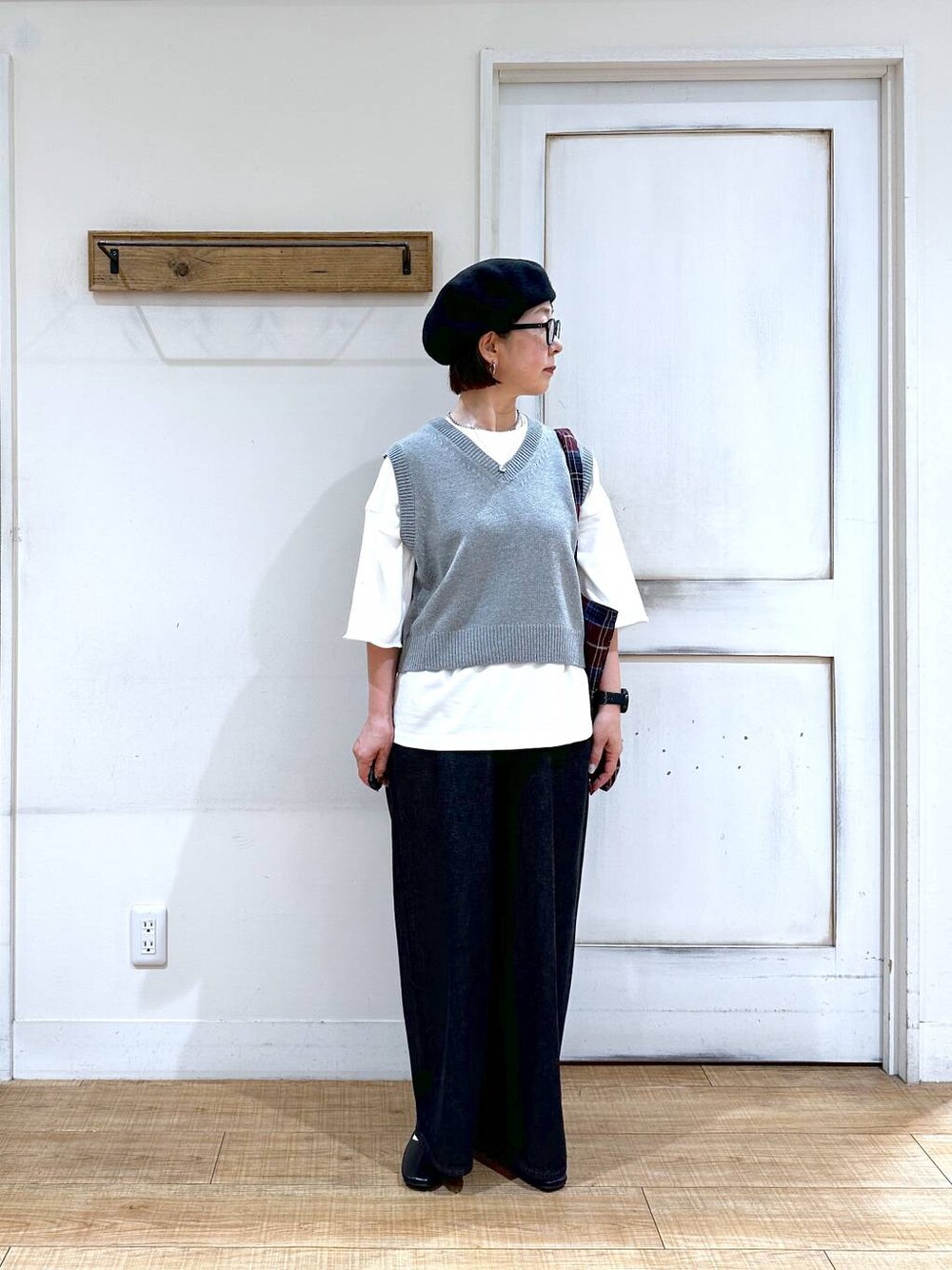 ホワイト系のTシャツ/カットソー、グレー系のベスト、ブラック系のパンプスを着用したレディースの秋コーディネートの1枚目の写真