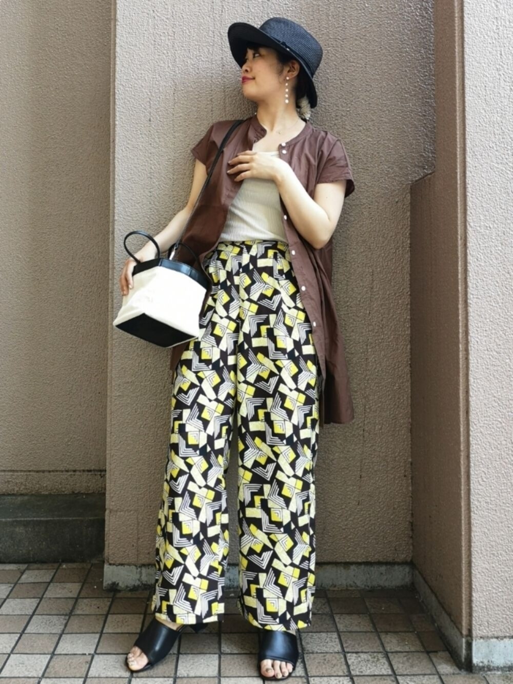 ブラウン系のその他パンツ、ブラック系のサンダル、ブラック系のトートバッグを着用したレディースの夏コーディネートの1枚目の写真