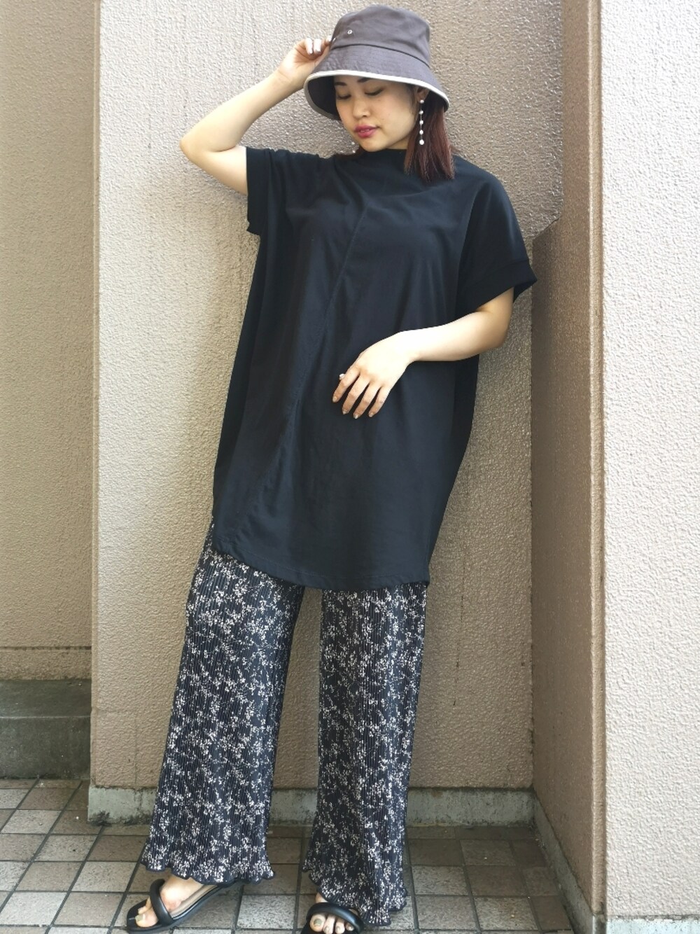 ブラック系のTシャツ/カットソー、ブラック系のサンダル、ブラウン系のキャップを着用したレディースの夏コーディネートの1枚目の写真