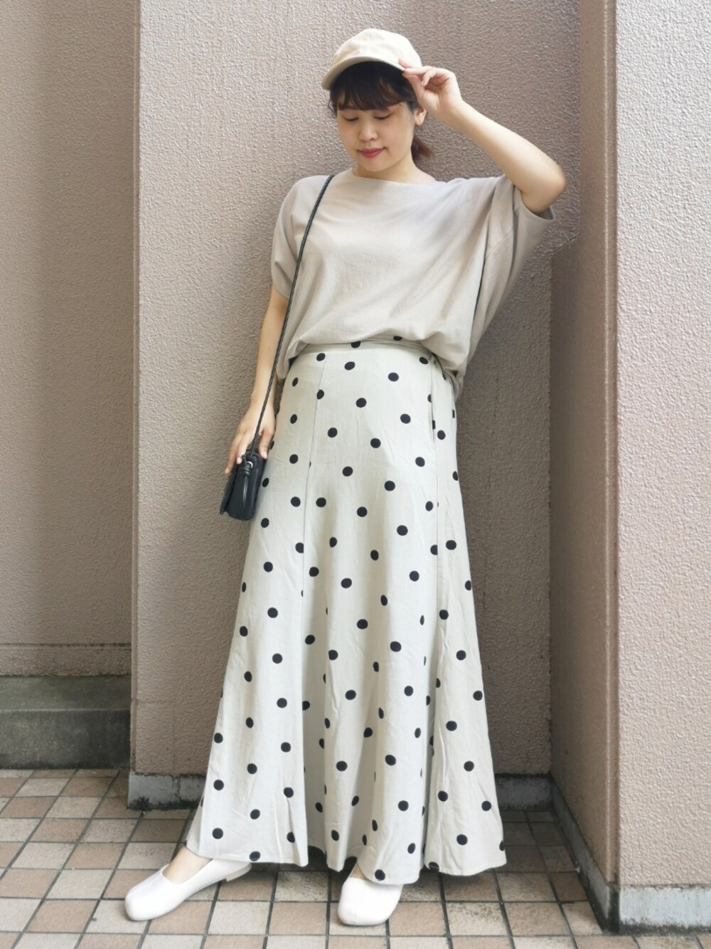 ベージュ系のニット/セーター、ブラック系のショルダーバッグ、ベージュ系のスカートを着用したレディースの夏コーディネートの1枚目の写真