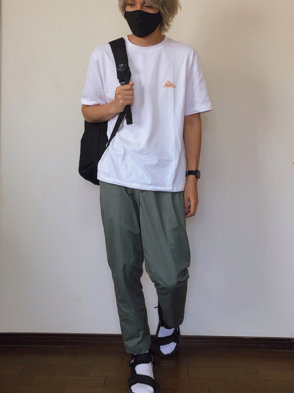 ホワイト系のTシャツ/カットソー、グリーン系のパンツ、ブラック系のサンダルを着用したメンズの夏コーディネートの1枚目の写真