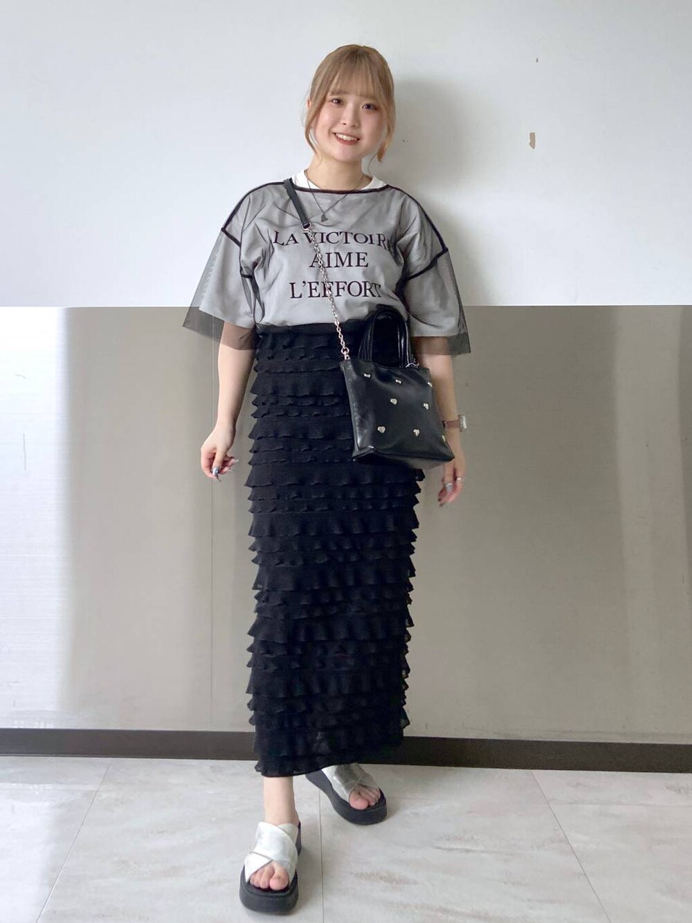 ブラック系のスカート、ホワイト系のTシャツ/カットソー、ブラック系のTシャツ/カットソーを着用したレディースの夏コーディネートの1枚目の写真