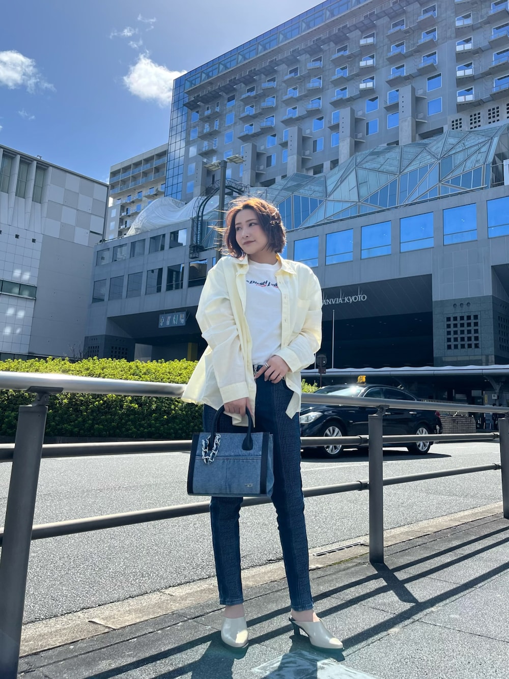 ホワイト系のシャツ/ブラウス、ホワイト系のTシャツ/カットソー、ブルー系のトートバッグを着用したレディースの春コーディネートの1枚目の写真
