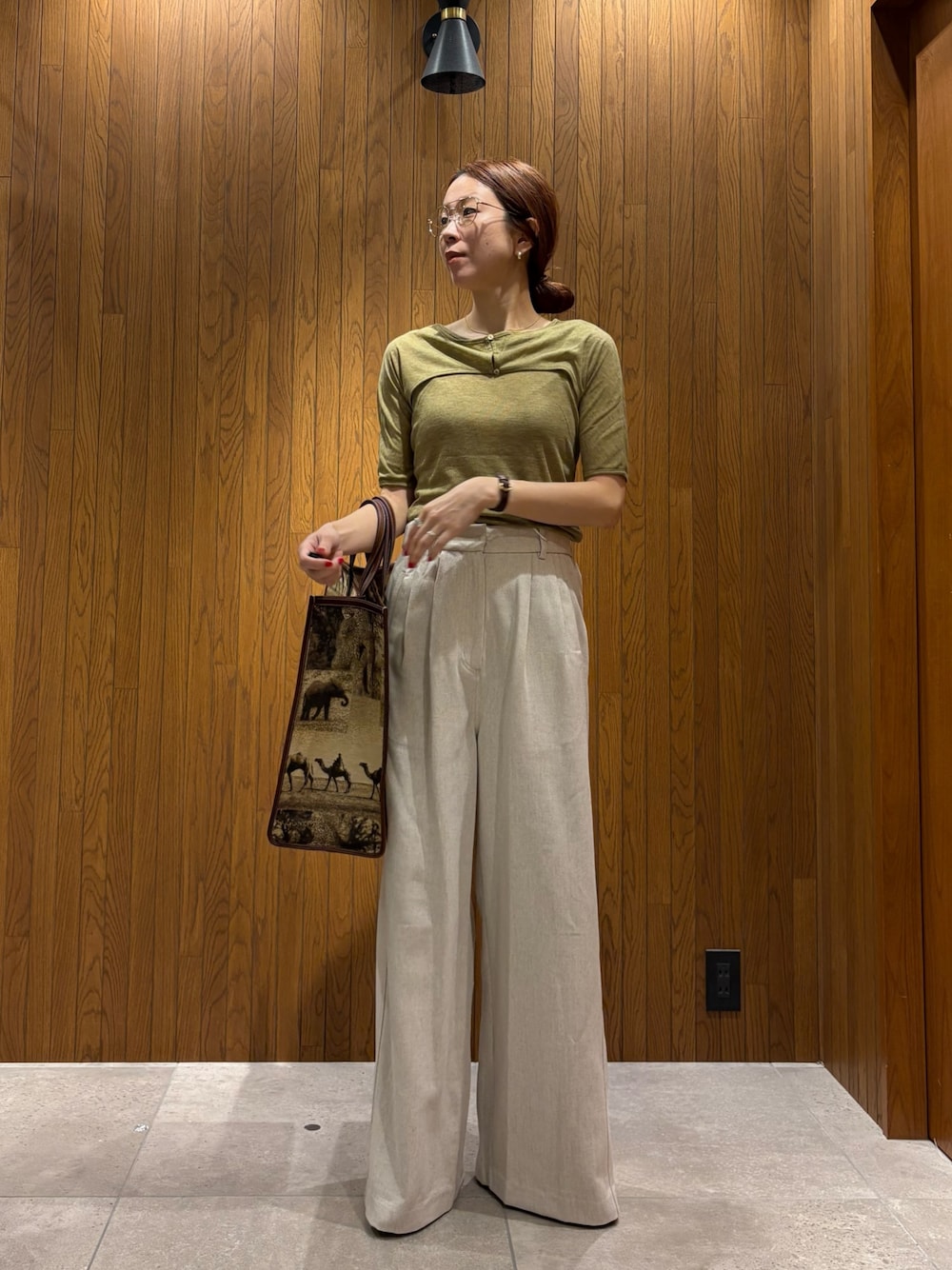 ホワイト系のその他パンツ、グリーン系のTシャツ/カットソー、ベージュ系のハンドバッグを着用したレディースの春コーディネートの1枚目の写真