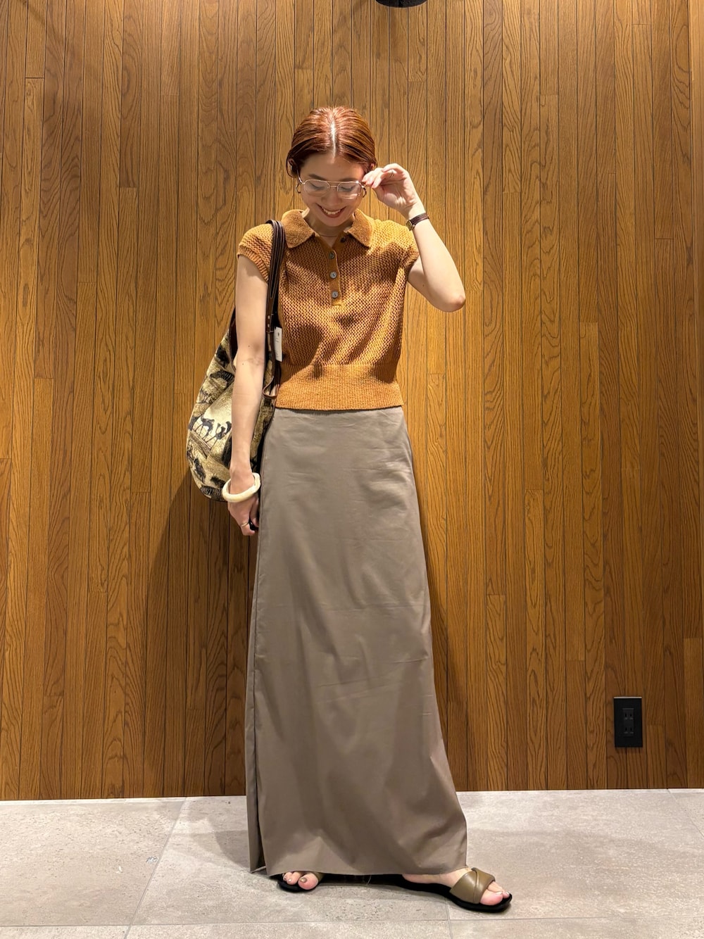 ブラウン系のニット/セーター、グレー系のスカート、ベージュ系のトートバッグを着用したレディースの夏コーディネートの1枚目の写真