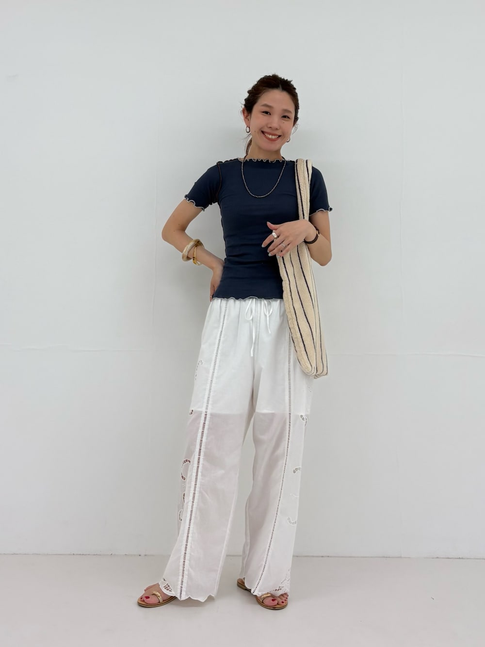 ブルー系のTシャツ/カットソー、ホワイト系のその他パンツ、ホワイト系のトートバッグを着用したレディースの春コーディネートの1枚目の写真