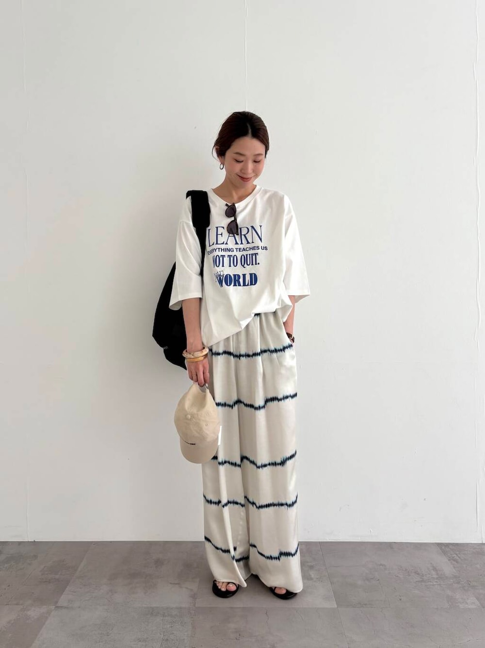 ブラック系のバックパック/リュック、その他のTシャツ/カットソー、ブラック系のサンダルを着用したレディースの春コーディネートの1枚目の写真