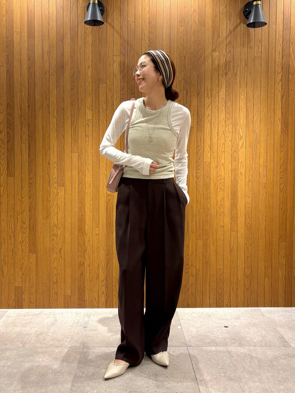 ブラウン系のその他パンツ、グレー系のスカート、ピンク系のショルダーバッグを着用したレディースの秋コーディネートの1枚目の写真