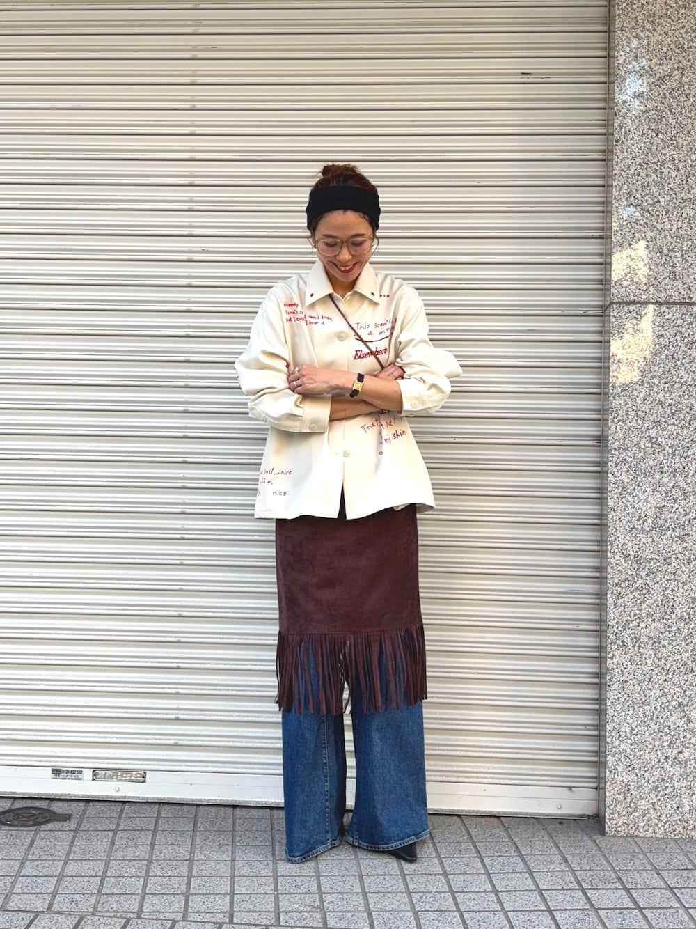 ホワイト系のTシャツ/カットソー、ブラウン系のスカート、ブルー系のデニムパンツを着用したレディースの秋コーディネートの1枚目の写真