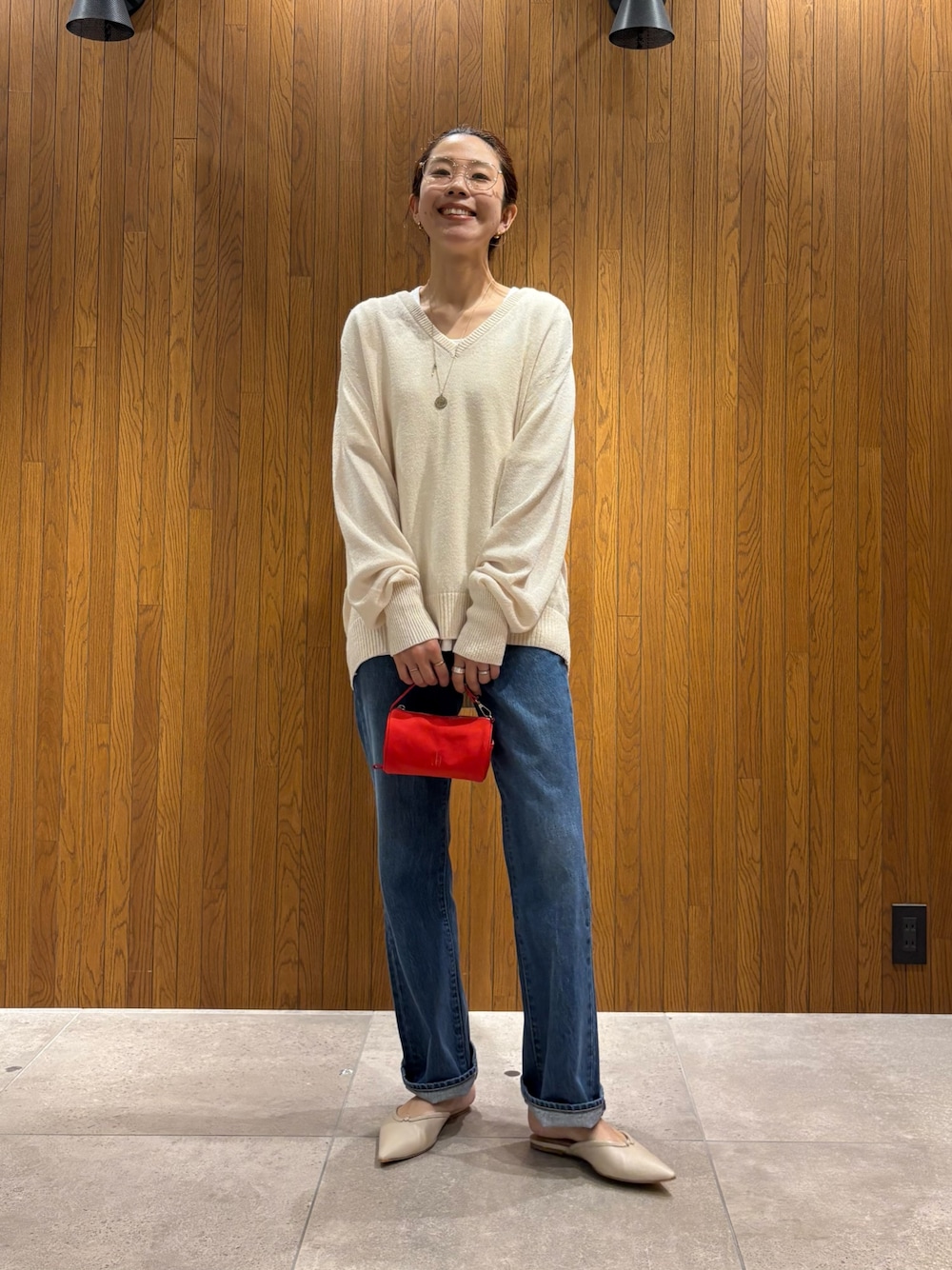 ベージュ系のニット/セーター、ホワイト系のTシャツ/カットソー、レッド系のハンドバッグを着用したレディースの秋コーディネートの1枚目の写真