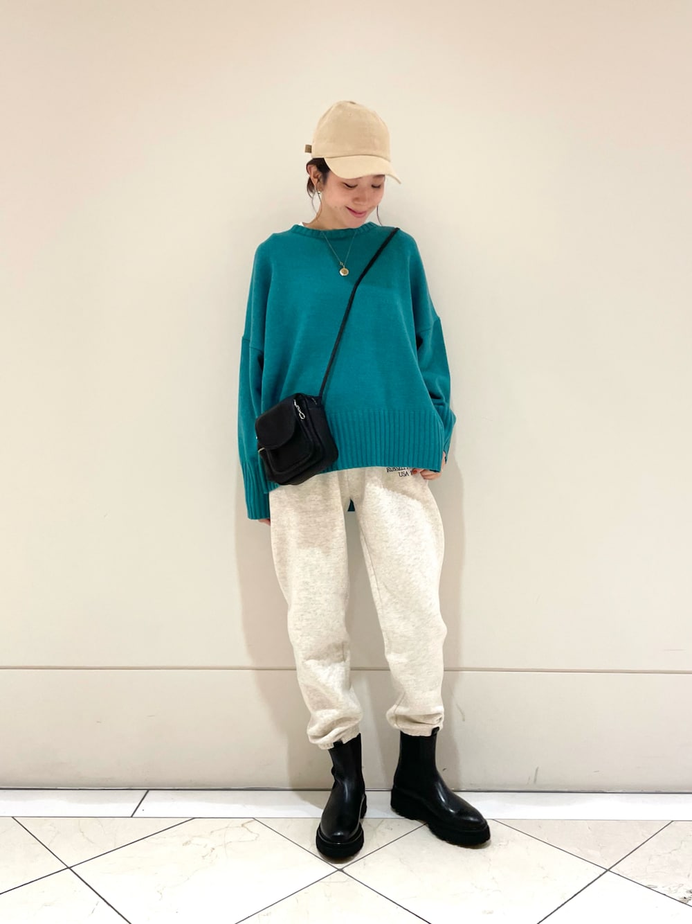 グレー系のその他パンツ、ブラック系のブーツ、グリーン系のニット/セーターを着用したレディースの冬コーディネートの1枚目の写真
