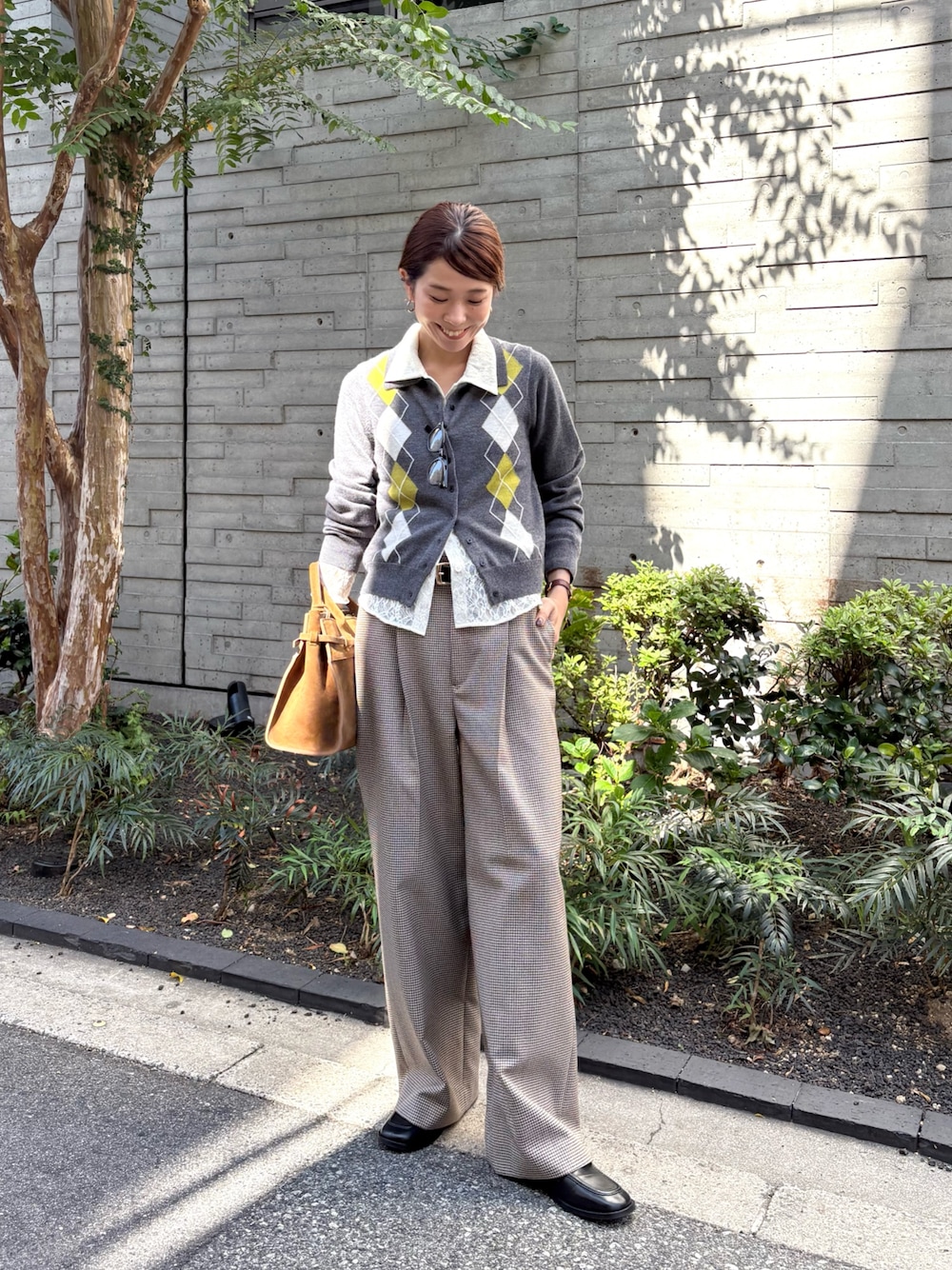 グレー系のニット/セーター、ホワイト系のシャツ/ブラウス、グレー系のその他パンツを着用したレディースの秋コーディネートの1枚目の写真