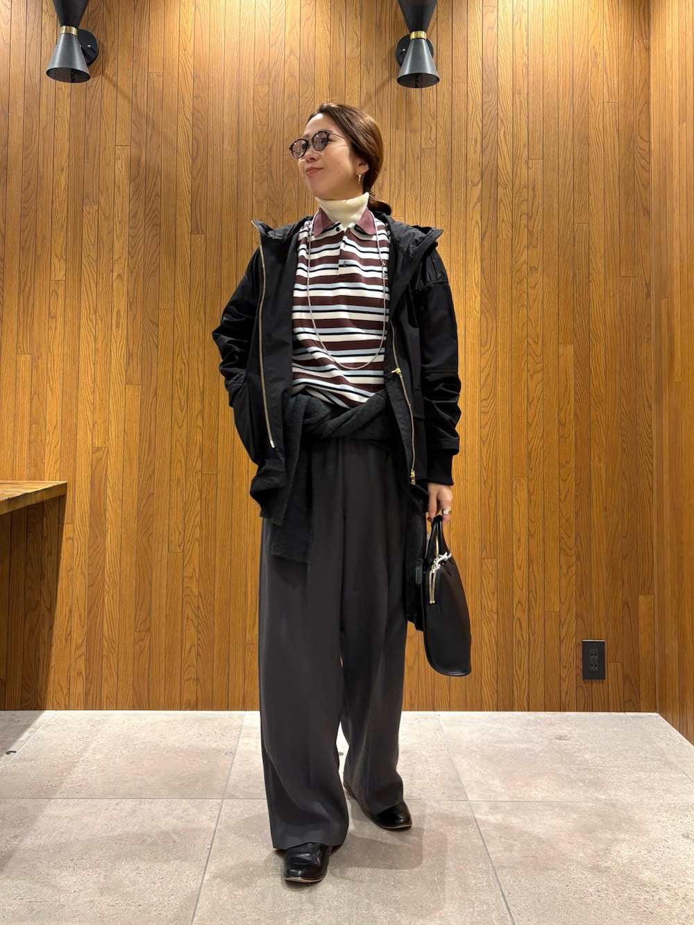 グレー系のその他パンツ、ブラック系のマウンテンパーカー、その他のポロシャツを着用したレディースの冬コーディネートの1枚目の写真