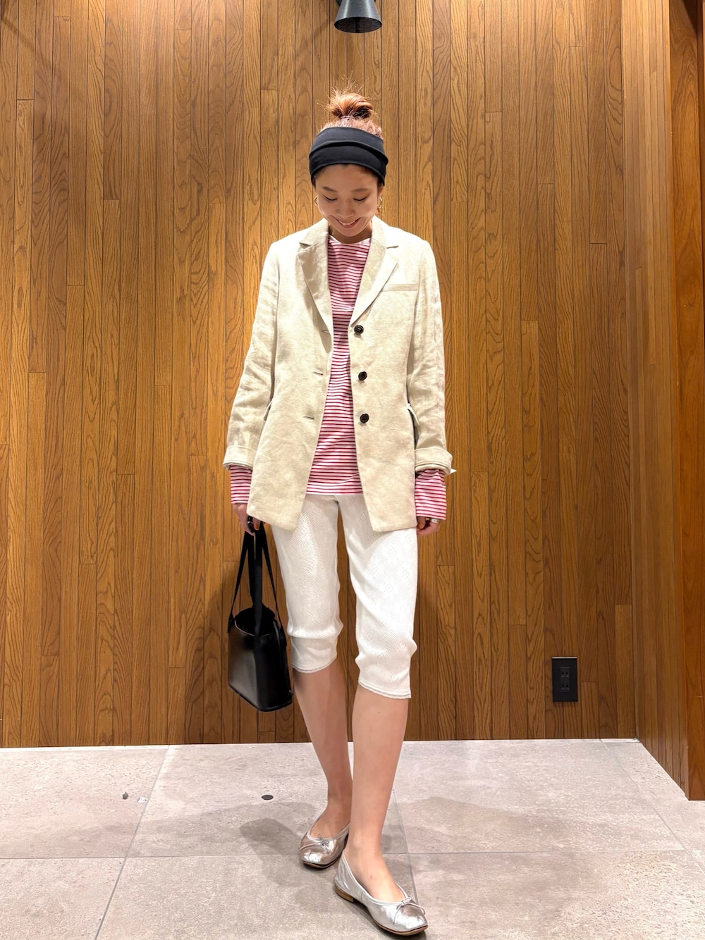 ベージュ系のその他アウター、レッド系のTシャツ/カットソー、ブラック系のハンドバッグを着用したレディースの春コーディネートの1枚目の写真