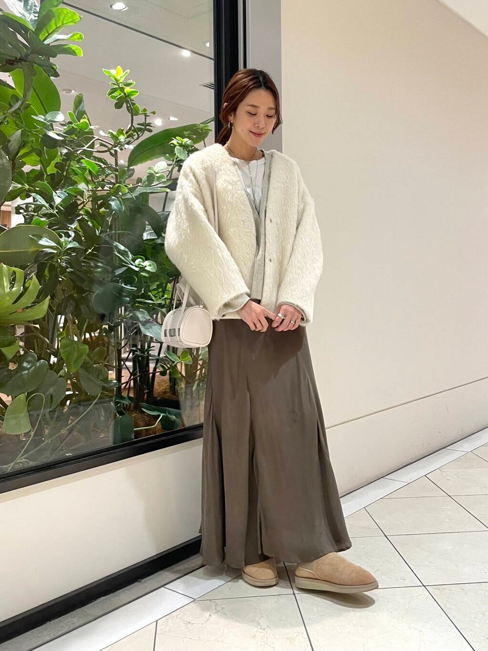 ホワイト系のボストンバッグ、グリーン系のスカート、ホワイト系のTシャツ/カットソーを着用したレディースの秋コーディネートの1枚目の写真