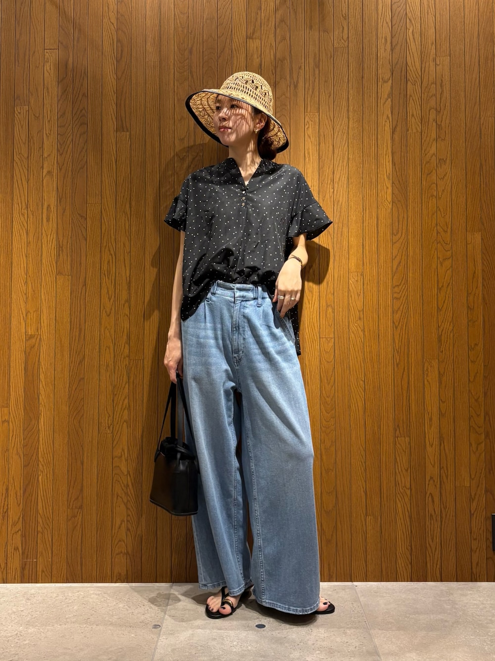 ブラック系のシャツ/ブラウス、ブルー系のデニムパンツ、ブラック系のサンダルを着用したレディースの春コーディネートの1枚目の写真