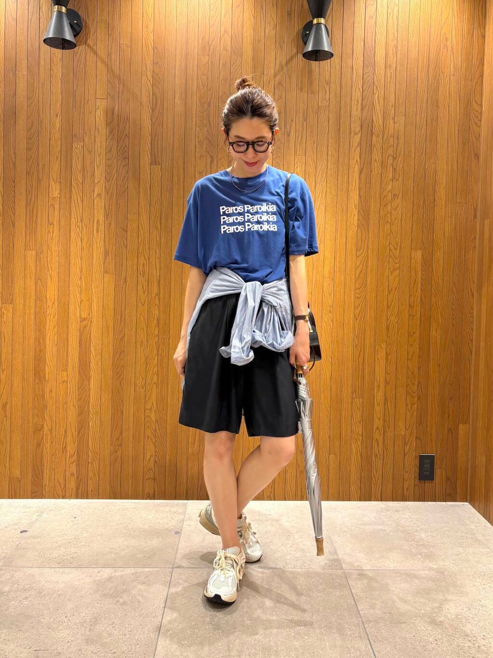 ブルー系のシャツ/ブラウス、シルバー系のスニーカー、ブラック系のショルダーバッグを着用したレディースの夏コーディネートの1枚目の写真