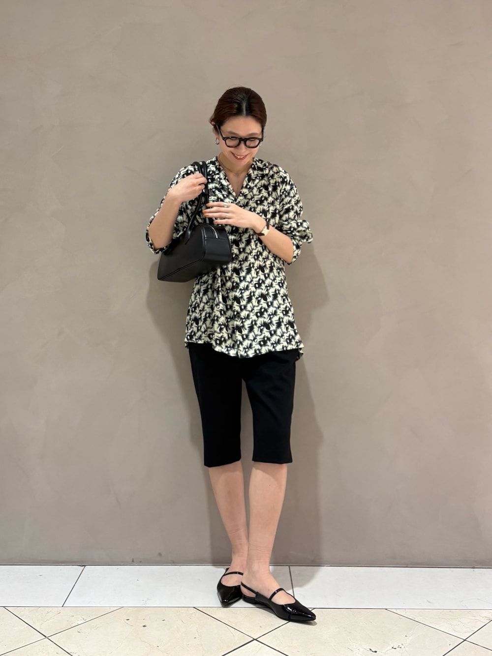 ブラック系のその他パンツ、ブラック系のパンプス、ホワイト系のシャツ/ブラウスを着用したレディースの春コーディネートの1枚目の写真