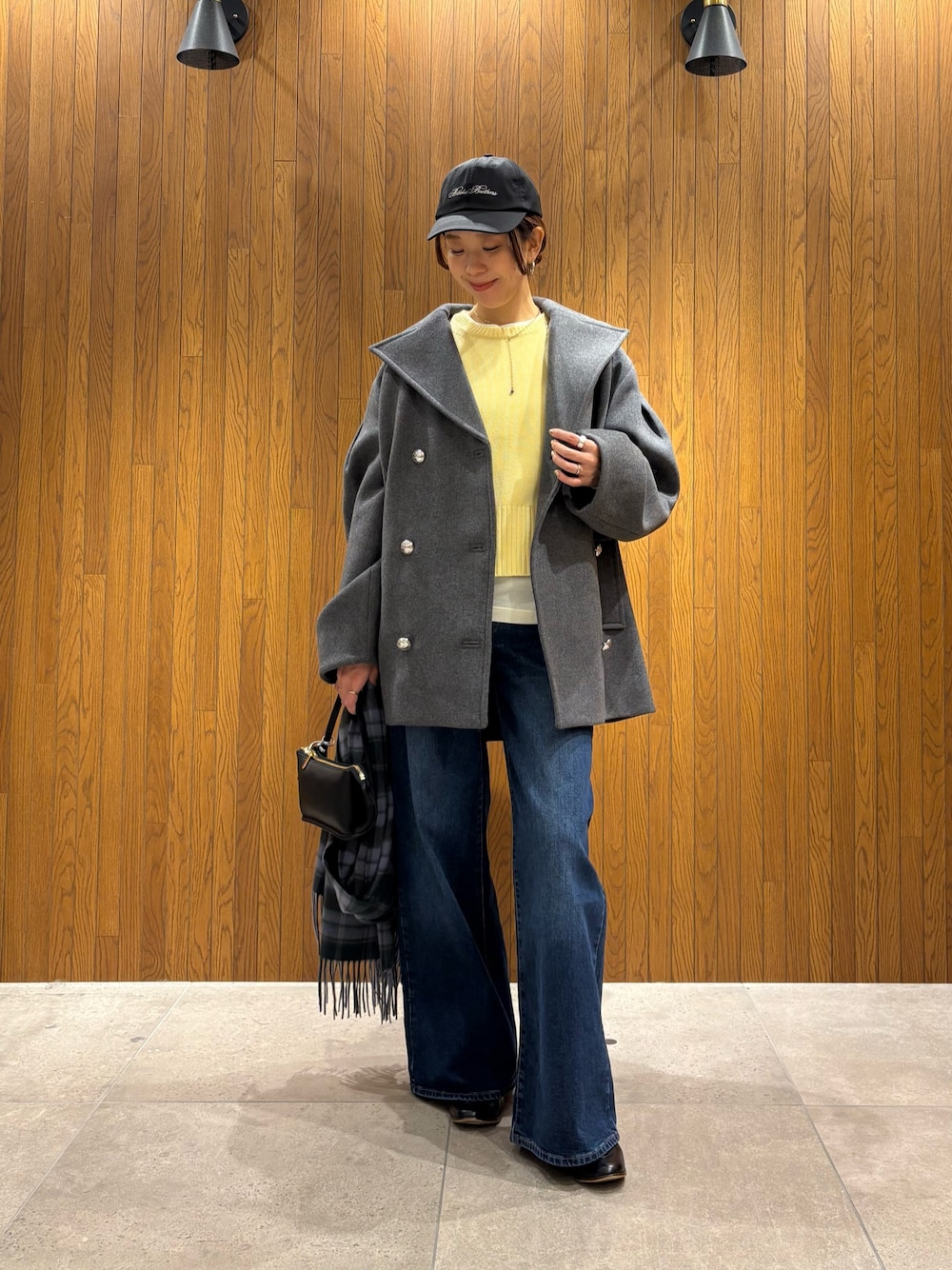 グレー系のその他アウター、イエロー系のニット/セーター、ブルー系のデニムパンツを着用したレディースの冬コーディネートの1枚目の写真