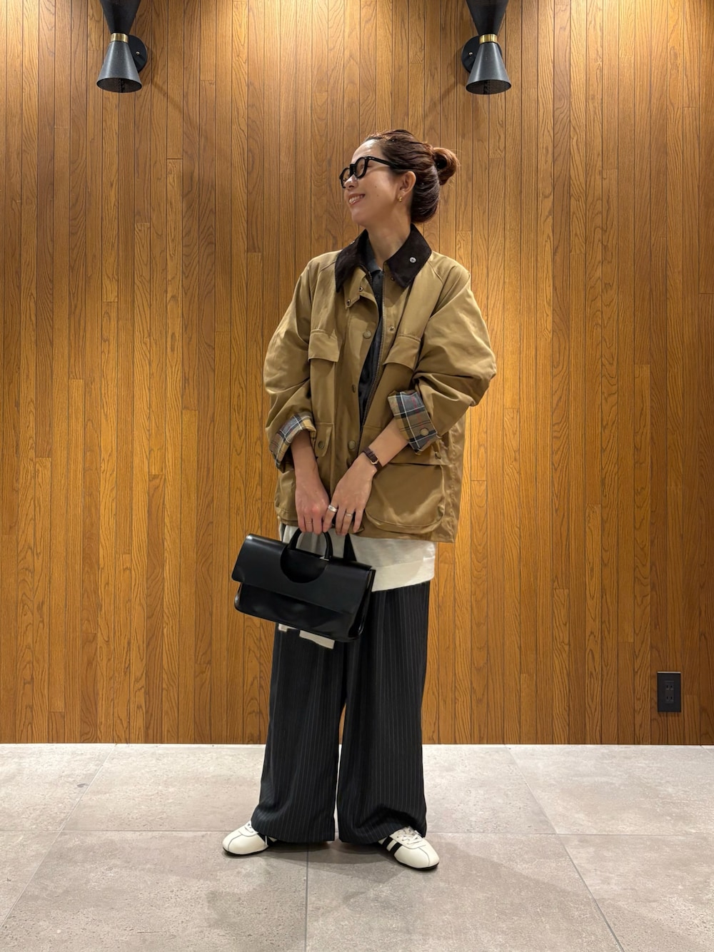 ホワイト系のスニーカー、ベージュ系のその他アウター、グレー系のニット/セーターを着用したレディースの秋コーディネートの1枚目の写真