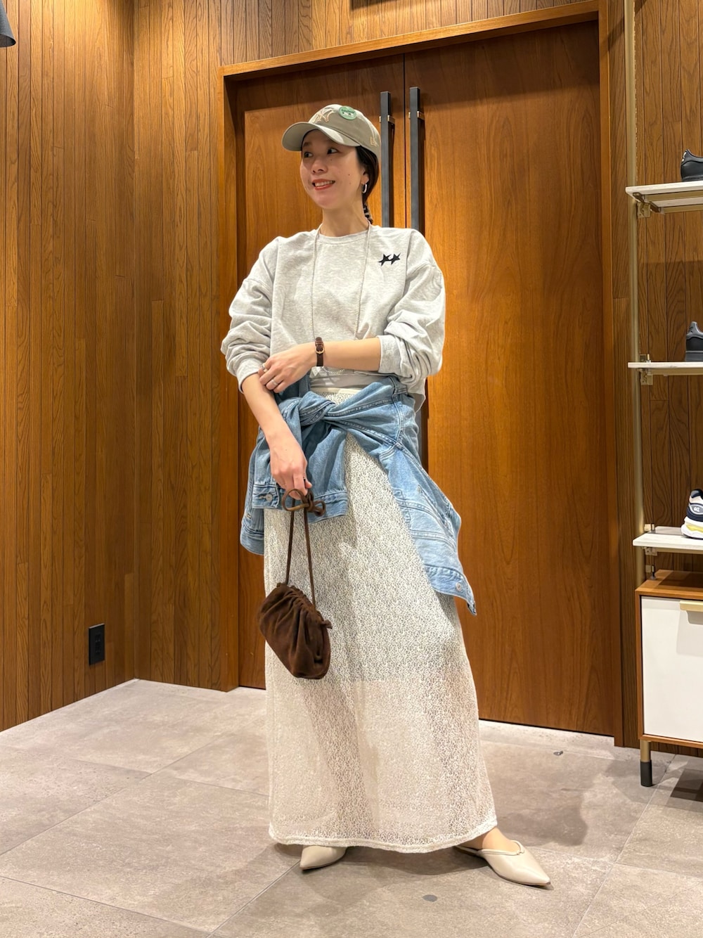 ホワイト系のスカート、ブルー系のデニムジャケット、グレー系のスウェットを着用したレディースの冬コーディネートの1枚目の写真