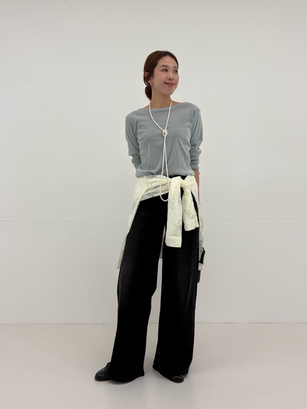 ブラック系のデニムパンツ、ホワイト系のシャツ/ブラウス、ブラック系のショルダーバッグを着用したレディースの夏コーディネートの1枚目の写真
