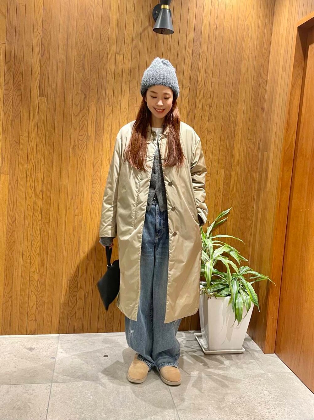 ブルー系のデニムパンツ、グレー系のカーディガン/ボレロ、ベージュ系のダウンジャケット/コートを着用したレディースの秋コーディネートの1枚目の写真